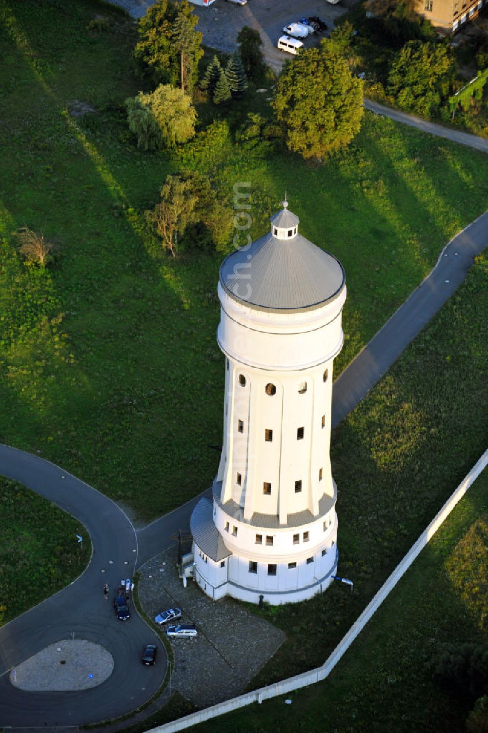 Eilenburg from above - Der etwa 60 Meter hohe Wasserturm in Eilenburg-Ost in Sachsen wurde 1916 in der aufwendigen Bauart Otto Intzes vom Unternehmen Dyckerhoff und Widmann AG für die große Zelluloidfabrik gebaut. Nachdem er in der Zeit der DDR immer mehr verfallen war, wurde er im Jahr 2002 wieder instandgesetzt. Der Turm dient nun als Löschwasserspeicher für das benachbarte Industrie- und Gewerbegebiet Kunstoffcenter am ECW-Wasserturm und gilt als das wohl eindrucksvollste technische Denkmal der Stadt. About 60 metres high water tower in Eilenburg-East in Saxony was build 1916 in elaborate style of Otto Intzes by company Dyckerhoff und Widmann AG for a big celluloid factory. Gone to rack during the time of DDR, the tower was refurbished in 2002. It now serves as a fire water reservoir for industrial area Kunstoffcenter am ECW-Wasserturm nearby and is regarded as the most impressive technical monument of the town.