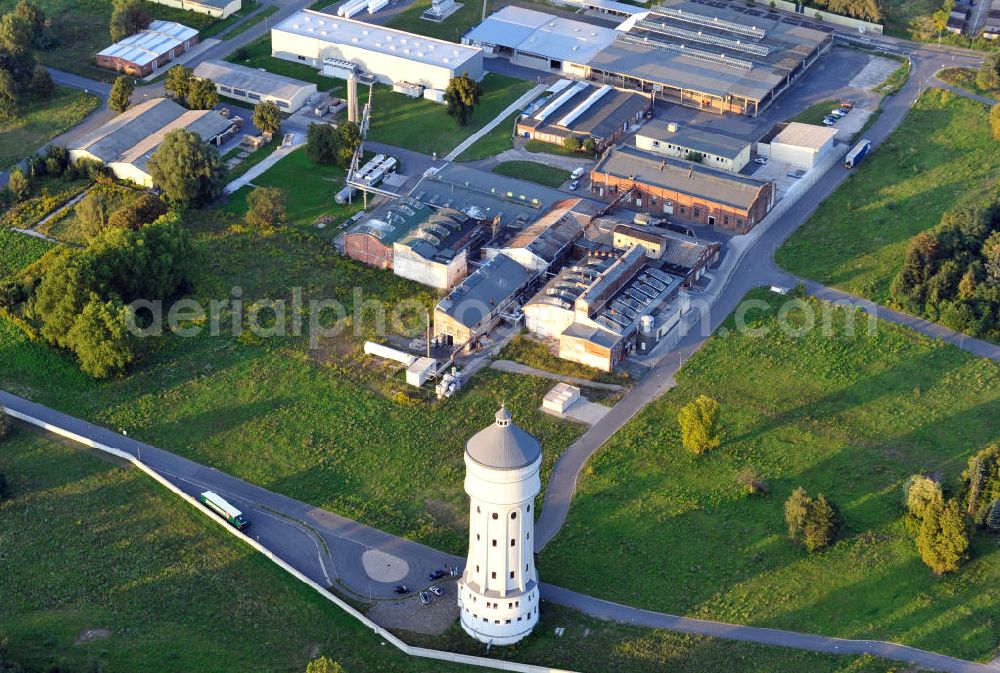 Aerial photograph Eilenburg - Der etwa 60 Meter hohe Wasserturm in Eilenburg-Ost in Sachsen wurde 1916 in der aufwendigen Bauart Otto Intzes vom Unternehmen Dyckerhoff und Widmann AG für die große Zelluloidfabrik gebaut. Nachdem er in der Zeit der DDR immer mehr verfallen war, wurde er im Jahr 2002 wieder instandgesetzt. Der Turm dient nun als Löschwasserspeicher für das benachbarte Industrie- und Gewerbegebiet Kunstoffcenter am ECW-Wasserturm und gilt als das wohl eindrucksvollste technische Denkmal der Stadt. About 60 metres high water tower in Eilenburg-East in Saxony was build 1916 in elaborate style of Otto Intzes by company Dyckerhoff und Widmann AG for a big celluloid factory. Gone to rack during the time of DDR, the tower was refurbished in 2002. It now serves as a fire water reservoir for industrial area Kunstoffcenter am ECW-Wasserturm nearby and is regarded as the most impressive technical monument of the town.