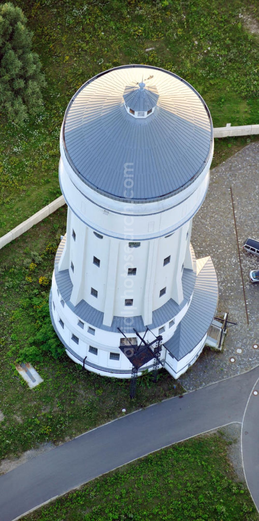 Eilenburg from above - Der etwa 60 Meter hohe Wasserturm in Eilenburg-Ost in Sachsen wurde 1916 in der aufwendigen Bauart Otto Intzes vom Unternehmen Dyckerhoff und Widmann AG für die große Zelluloidfabrik gebaut. Nachdem er in der Zeit der DDR immer mehr verfallen war, wurde er im Jahr 2002 wieder instandgesetzt. Der Turm dient nun als Löschwasserspeicher für das benachbarte Industrie- und Gewerbegebiet Kunstoffcenter am ECW-Wasserturm und gilt als das wohl eindrucksvollste technische Denkmal der Stadt. About 60 metres high water tower in Eilenburg-East in Saxony was build 1916 in elaborate style of Otto Intzes by company Dyckerhoff und Widmann AG for a big celluloid factory. Gone to rack during the time of DDR, the tower was refurbished in 2002. It now serves as a fire water reservoir for industrial area Kunstoffcenter am ECW-Wasserturm nearby and is regarded as the most impressive technical monument of the town.