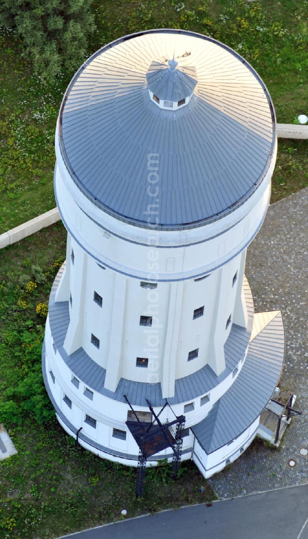 Eilenburg from the bird's eye view: Der etwa 60 Meter hohe Wasserturm in Eilenburg-Ost in Sachsen wurde 1916 in der aufwendigen Bauart Otto Intzes vom Unternehmen Dyckerhoff und Widmann AG für die große Zelluloidfabrik gebaut. Nachdem er in der Zeit der DDR immer mehr verfallen war, wurde er im Jahr 2002 wieder instandgesetzt. Der Turm dient nun als Löschwasserspeicher für das benachbarte Industrie- und Gewerbegebiet Kunstoffcenter am ECW-Wasserturm und gilt als das wohl eindrucksvollste technische Denkmal der Stadt. About 60 metres high water tower in Eilenburg-East in Saxony was build 1916 in elaborate style of Otto Intzes by company Dyckerhoff und Widmann AG for a big celluloid factory. Gone to rack during the time of DDR, the tower was refurbished in 2002. It now serves as a fire water reservoir for industrial area Kunstoffcenter am ECW-Wasserturm nearby and is regarded as the most impressive technical monument of the town.