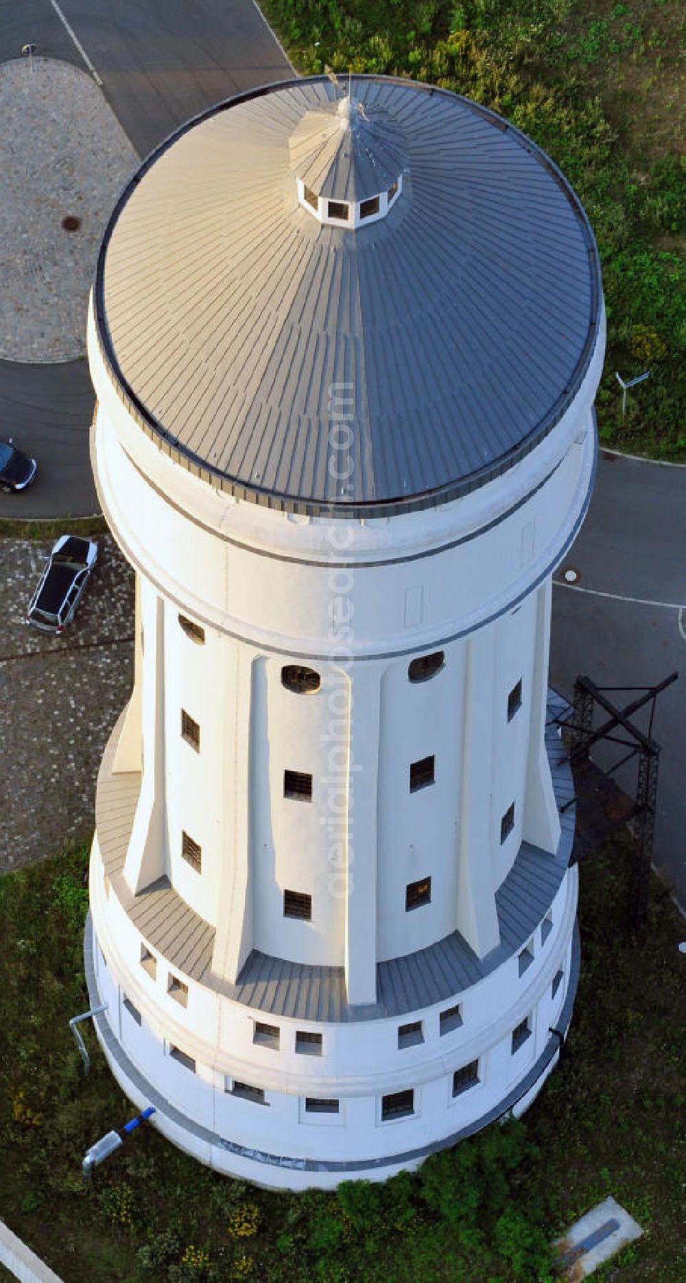 Aerial image Eilenburg - Der etwa 60 Meter hohe Wasserturm in Eilenburg-Ost in Sachsen wurde 1916 in der aufwendigen Bauart Otto Intzes vom Unternehmen Dyckerhoff und Widmann AG für die große Zelluloidfabrik gebaut. Nachdem er in der Zeit der DDR immer mehr verfallen war, wurde er im Jahr 2002 wieder instandgesetzt. Der Turm dient nun als Löschwasserspeicher für das benachbarte Industrie- und Gewerbegebiet Kunstoffcenter am ECW-Wasserturm und gilt als das wohl eindrucksvollste technische Denkmal der Stadt. About 60 metres high water tower in Eilenburg-East in Saxony was build 1916 in elaborate style of Otto Intzes by company Dyckerhoff und Widmann AG for a big celluloid factory. Gone to rack during the time of DDR, the tower was refurbished in 2002. It now serves as a fire water reservoir for industrial area Kunstoffcenter am ECW-Wasserturm nearby and is regarded as the most impressive technical monument of the town.