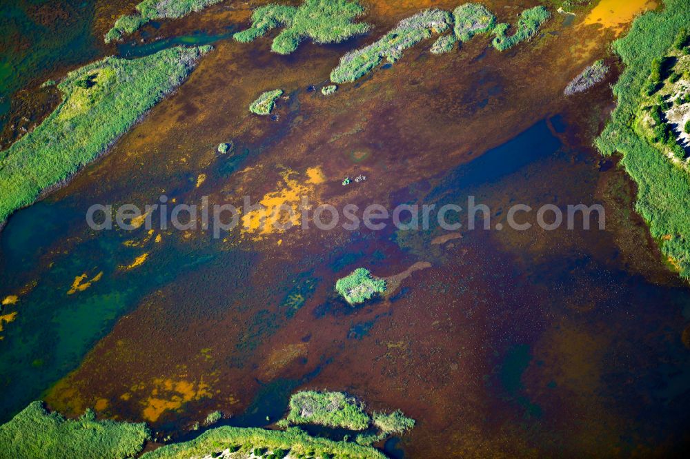 Kolonie Fortschritt from the bird's eye view: Colorful water surface and water discoloration in open-cast mining, overburden and residual areas due to sulfuric acid compounds and oxidized iron compounds These are dissolved by rising groundwater and lead to acidification and clogging of the water. in Kolonie Fortschritt in the state Brandenburg, Germany