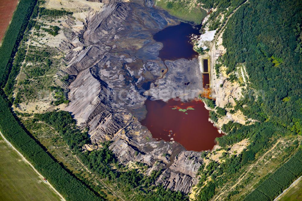 Schipkau from above - Colorful water surface and water discoloration in open-cast mining, overburden and residual areas due to sulfuric acid compounds and oxidized iron compounds These are dissolved by rising groundwater and lead to acidification and clogging of the water. in Schipkau in the state Brandenburg, Germany