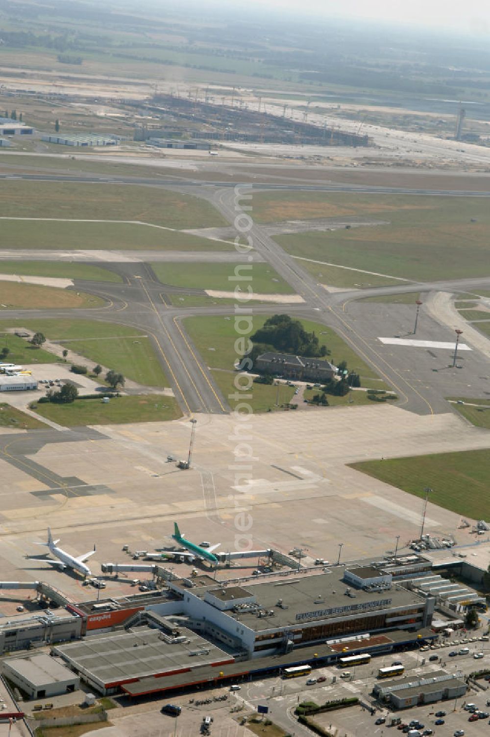 Aerial photograph Berlin - Blick auf die Abfertigungshalle am Flughafen Berlin-Schönefeld. Wenn der Flughafen BBI in absehbarer Zeit in Betrieb geht, wird dieser noch aus INTERFLUG-Zeiten stammende Bereich überflüssig. Im Gespräch ist eine Weiternutzung / Umbau des Abfertigungsbereiches zum Empfangsbereich für die Regierungsfliegerstaffel der Bundesregierung.