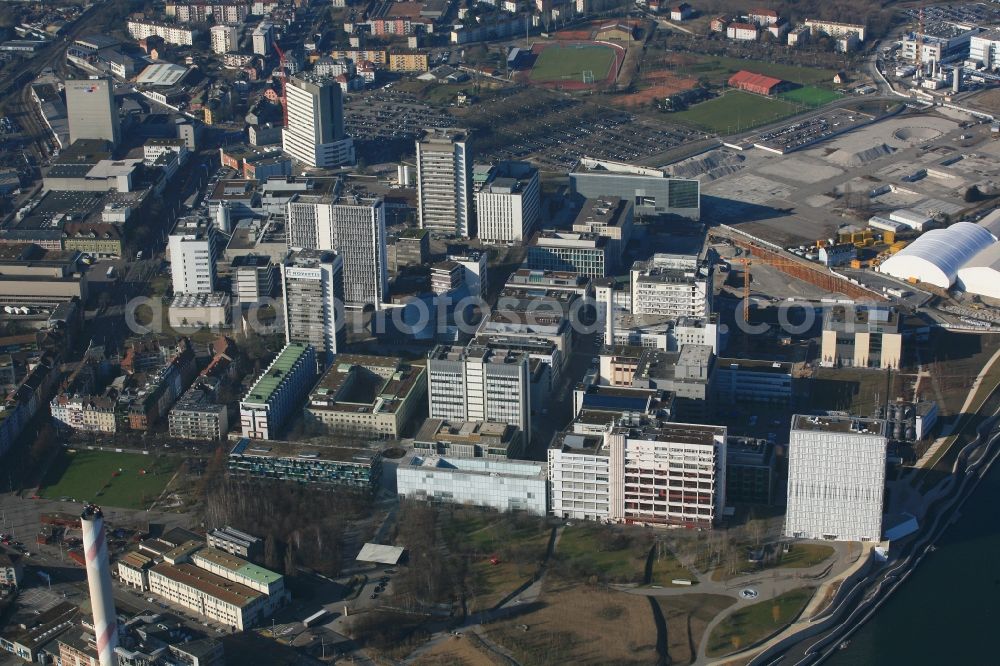 Basel from above - Buildings and production halls on the factory premises of pharmaceutical company Novartis in Basel in Switzerland. The Novartis Campus is located in the district of St. Johann and is global headquarter of the pharmaceutical giant with its centre for Research, Development and Management. The buildings are designed by well-known architects. On the grounds of the former Rhine harbor St. Johann, there is built a water front to the river Rhine