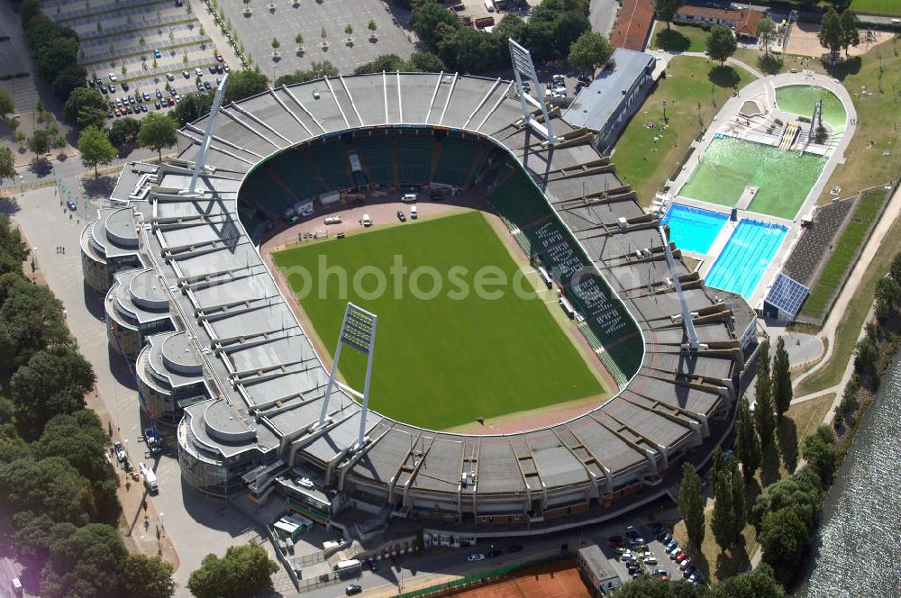 BREMEN from above - Das Weserstadion in Bremen ist das Stadion des deutschen Fußball-Bundesligisten Werder Bremen. Es liegt direkt an der Weser, am rechten Weserufer, in der Pauliner Marsch, einem Überflutungsgebiet vor dem Osterdeich im Stadtteil Östliche Vorstadt, Ortsteil Peterswerder.Das Bremer Weserstadion wurde 1909 vom Allgemeinen Bremer Turn- und Sportverein als Sportplatz erbaut und nach seinem ersten Umbau im Jahre 1926 ABTS-Kampfbahn benannt. Der heutige Name, der auf die unmittelbare Lage an der Weser zurückgeht, besteht seit 1930. Seit dieser Zeit trägt dort auch der SV Werder Bremen seine Spiele aus. Auch der Bremer Sport-Verein von 1906 trug im Weserstadion seine Oberligaspiele bis 1963 aus. Zu Beginn der ersten Saison der Fußball-Bundesliga (1963) erhielt das Stadion seine erste überdachte Tribüne. In den folgenden Jahrzehnten wurden auch die an deren Tribünen erbaut und sukzessive modernisiert. 1992 wurde erstmals in einem Stadion eine VIP-Loge eingeführt. Im Jahr 2009 ist der Umbau des Weserstadions zu einem reinen Fußballstadion geplant. Bremer Weser-Stadion GmbH, Franz-Böhmert-Str. 7 , 28205 Bremen,Tel.: 0421 / 49 131 10