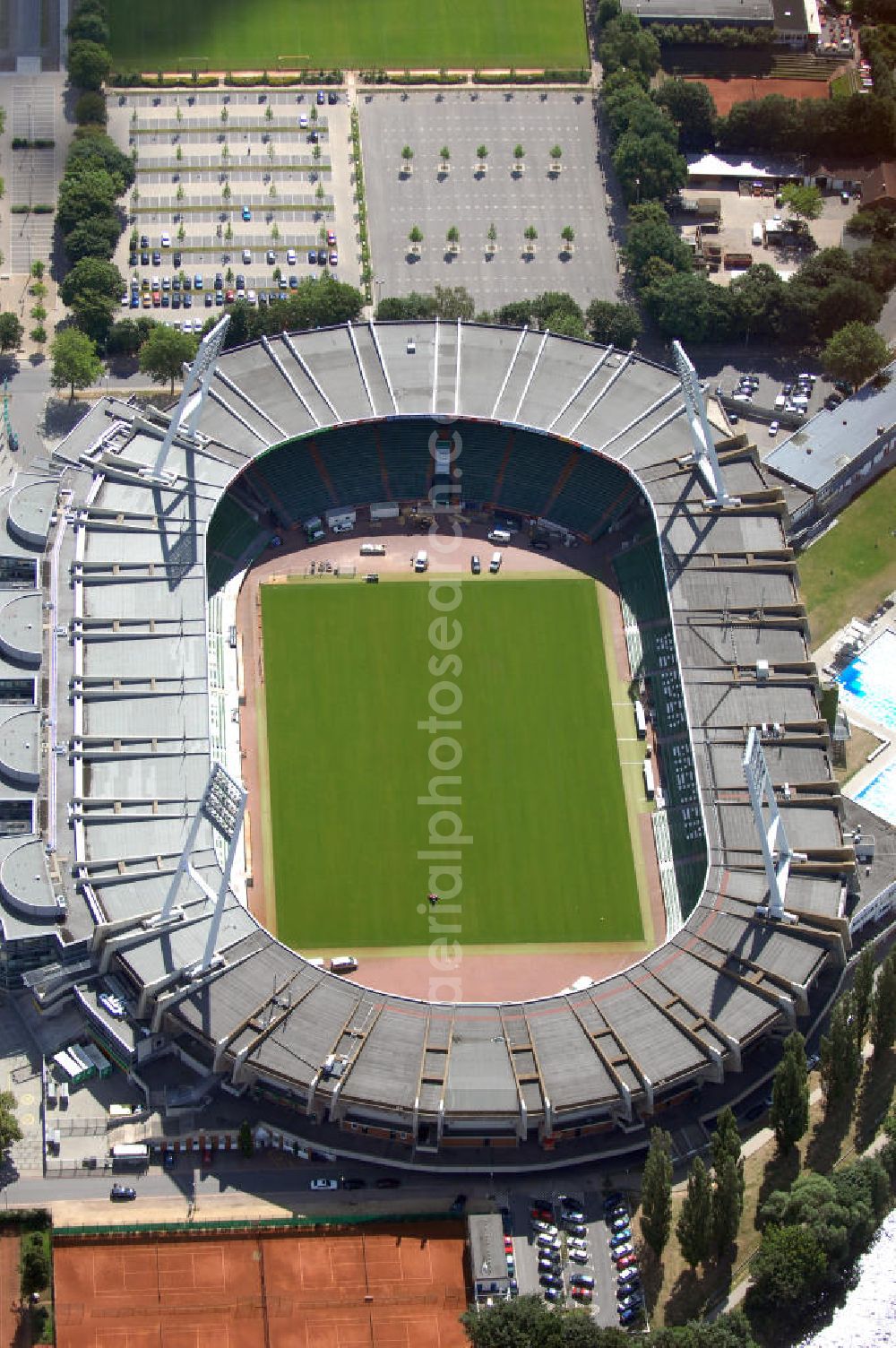 BREMEN from the bird's eye view: Das Weserstadion in Bremen ist das Stadion des deutschen Fußball-Bundesligisten Werder Bremen. Es liegt direkt an der Weser, am rechten Weserufer, in der Pauliner Marsch, einem Überflutungsgebiet vor dem Osterdeich im Stadtteil Östliche Vorstadt, Ortsteil Peterswerder.Das Bremer Weserstadion wurde 1909 vom Allgemeinen Bremer Turn- und Sportverein als Sportplatz erbaut und nach seinem ersten Umbau im Jahre 1926 ABTS-Kampfbahn benannt. Der heutige Name, der auf die unmittelbare Lage an der Weser zurückgeht, besteht seit 1930. Seit dieser Zeit trägt dort auch der SV Werder Bremen seine Spiele aus. Auch der Bremer Sport-Verein von 1906 trug im Weserstadion seine Oberligaspiele bis 1963 aus. Zu Beginn der ersten Saison der Fußball-Bundesliga (1963) erhielt das Stadion seine erste überdachte Tribüne. In den folgenden Jahrzehnten wurden auch die an deren Tribünen erbaut und sukzessive modernisiert. 1992 wurde erstmals in einem Stadion eine VIP-Loge eingeführt. Im Jahr 2009 ist der Umbau des Weserstadions zu einem reinen Fußballstadion geplant. Bremer Weser-Stadion GmbH, Franz-Böhmert-Str. 7 , 28205 Bremen,Tel.: 0421 / 49 131 10