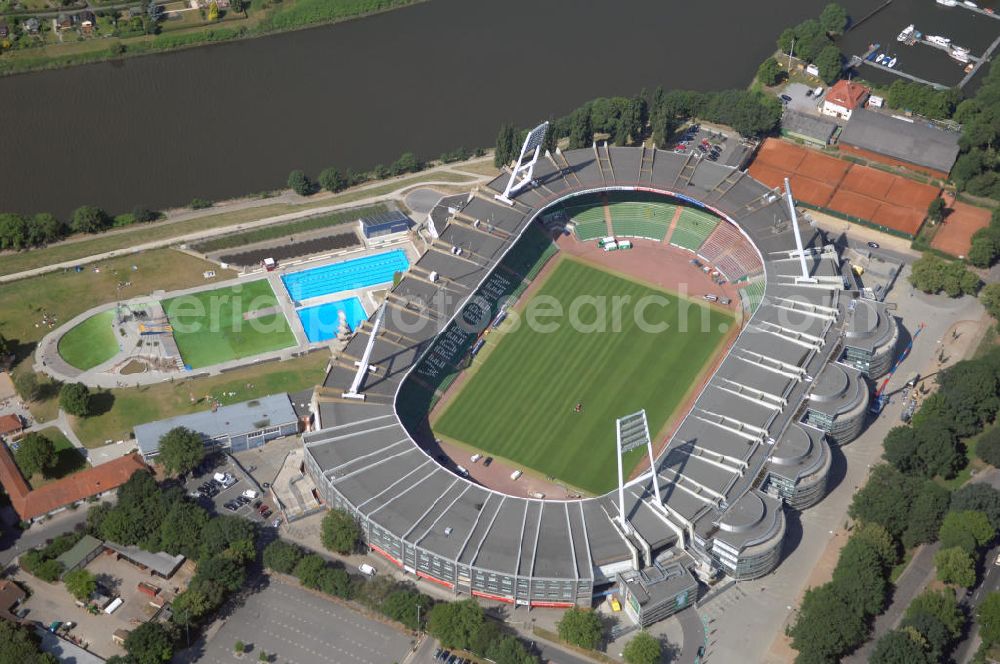 Aerial photograph BREMEN - Das Weserstadion in Bremen ist das Stadion des deutschen Fußball-Bundesligisten Werder Bremen. Es liegt direkt an der Weser, am rechten Weserufer, in der Pauliner Marsch, einem Überflutungsgebiet vor dem Osterdeich im Stadtteil Östliche Vorstadt, Ortsteil Peterswerder.Das Bremer Weserstadion wurde 1909 vom Allgemeinen Bremer Turn- und Sportverein als Sportplatz erbaut und nach seinem ersten Umbau im Jahre 1926 ABTS-Kampfbahn benannt. Der heutige Name, der auf die unmittelbare Lage an der Weser zurückgeht, besteht seit 1930. Seit dieser Zeit trägt dort auch der SV Werder Bremen seine Spiele aus. Auch der Bremer Sport-Verein von 1906 trug im Weserstadion seine Oberligaspiele bis 1963 aus. Zu Beginn der ersten Saison der Fußball-Bundesliga (1963) erhielt das Stadion seine erste überdachte Tribüne. In den folgenden Jahrzehnten wurden auch die an deren Tribünen erbaut und sukzessive modernisiert. 1992 wurde erstmals in einem Stadion eine VIP-Loge eingeführt. Im Jahr 2009 ist der Umbau des Weserstadions zu einem reinen Fußballstadion geplant. Bremer Weser-Stadion GmbH, Franz-Böhmert-Str. 7 , 28205 Bremen,Tel.: 0421 / 49 131 10