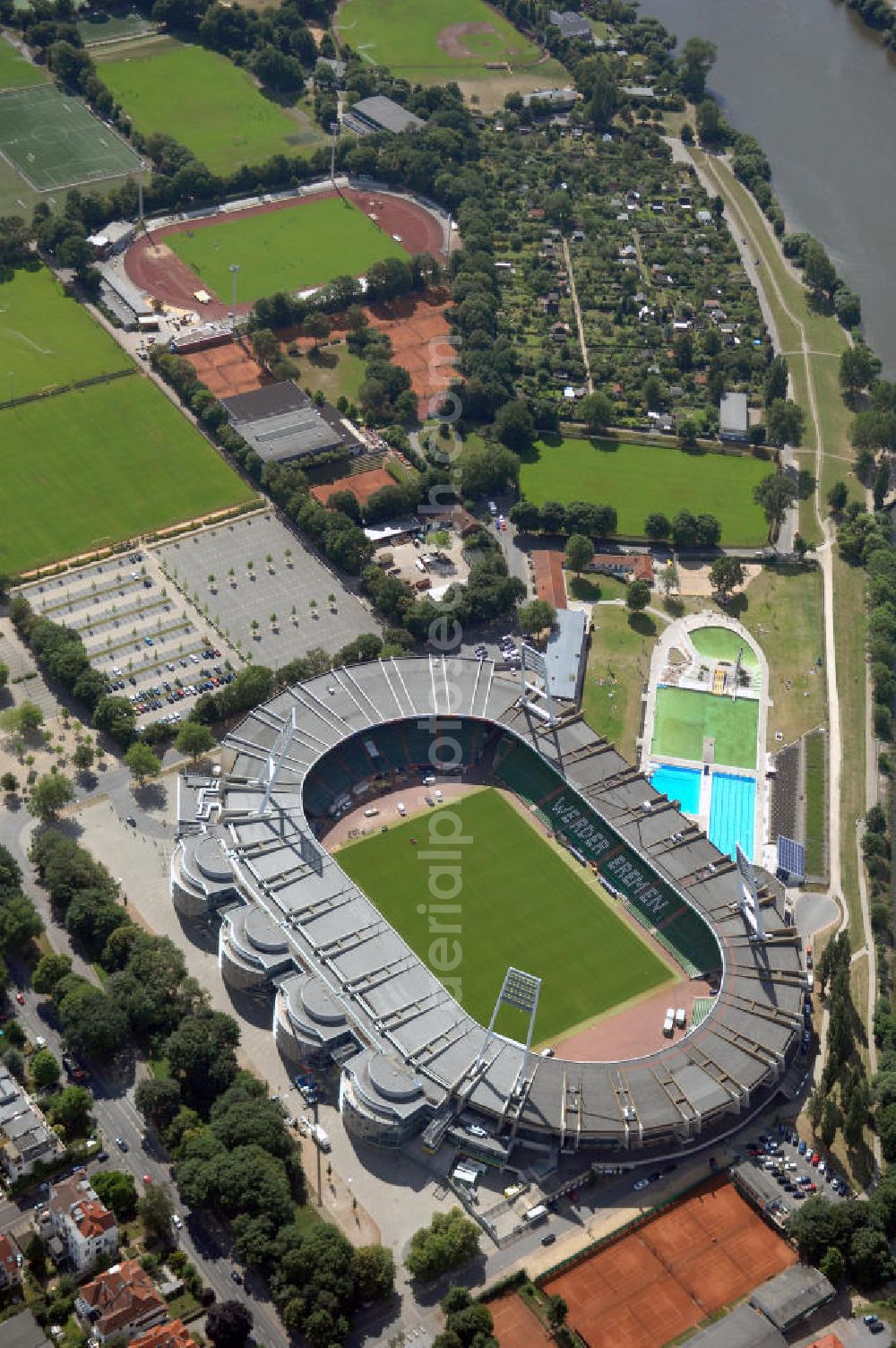 Aerial photograph BREMEN - Das Weserstadion in Bremen ist das Stadion des deutschen Fußball-Bundesligisten Werder Bremen. Es liegt direkt an der Weser, am rechten Weserufer, in der Pauliner Marsch, einem Überflutungsgebiet vor dem Osterdeich im Stadtteil Östliche Vorstadt, Ortsteil Peterswerder.Das Bremer Weserstadion wurde 1909 vom Allgemeinen Bremer Turn- und Sportverein als Sportplatz erbaut und nach seinem ersten Umbau im Jahre 1926 ABTS-Kampfbahn benannt. Der heutige Name, der auf die unmittelbare Lage an der Weser zurückgeht, besteht seit 1930. Seit dieser Zeit trägt dort auch der SV Werder Bremen seine Spiele aus. Auch der Bremer Sport-Verein von 1906 trug im Weserstadion seine Oberligaspiele bis 1963 aus. Zu Beginn der ersten Saison der Fußball-Bundesliga (1963) erhielt das Stadion seine erste überdachte Tribüne. In den folgenden Jahrzehnten wurden auch die an deren Tribünen erbaut und sukzessive modernisiert. 1992 wurde erstmals in einem Stadion eine VIP-Loge eingeführt. Im Jahr 2009 ist der Umbau des Weserstadions zu einem reinen Fußballstadion geplant. Bremer Weser-Stadion GmbH, Franz-Böhmert-Str. 7 , 28205 Bremen,Tel.: 0421 / 49 131 10