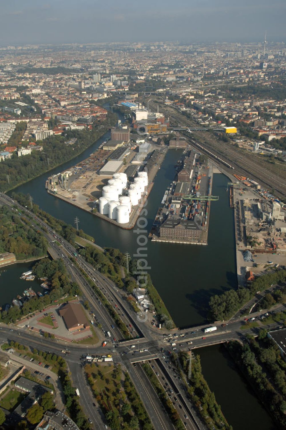 Berlin from above - Der Berliner Westhafen ist ein Binnenhafen im Ortsteil Moabit des Bezirks Mitte. Der Westhafen ist mit einer Fläche von 430.000 m² der größte Hafen der Stadt und ein bedeutender Umschlag- und Lagerplatz für die Binnenschifffahrt. Die Berliner Hafen-und Lagerhausgesellschaft mbH, kurz BEHALA genannt, betreibt in Berlin mehrere Binnenhäfen mit den dazugehörigen Lagerhäusern, dem Güterumschlag, einer Bauschuttentsorgung, den Hafenbahnen, und die Vermietung von Immobilien auf den Hafengeländen. Sie ist ein Eigenbetrieb der Stadt Berlin. Weitere Informationen unter