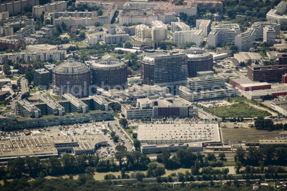 Aerial image Wien - Gasometer Vienna with the shopping mall Gasometer City in the district of Simmering in Vienna in Austria. The four former gas tanks and their surrounding area have been converted to a residential and business quarter