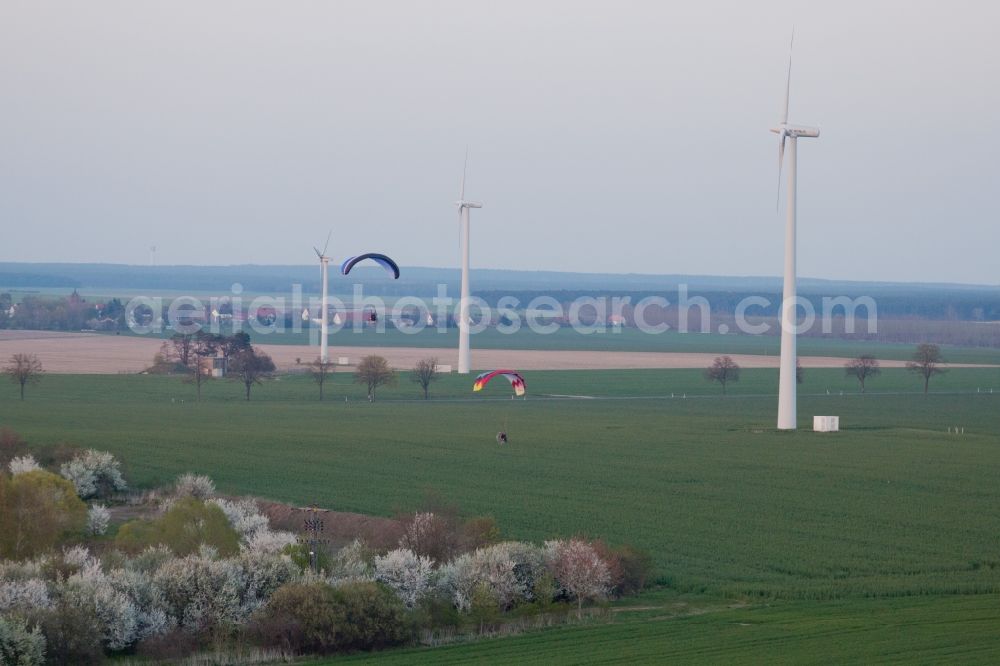 Aerial image Jüterbog - Wind turbine windmills with paragliders on a field in Jueterbog in the state Brandenburg