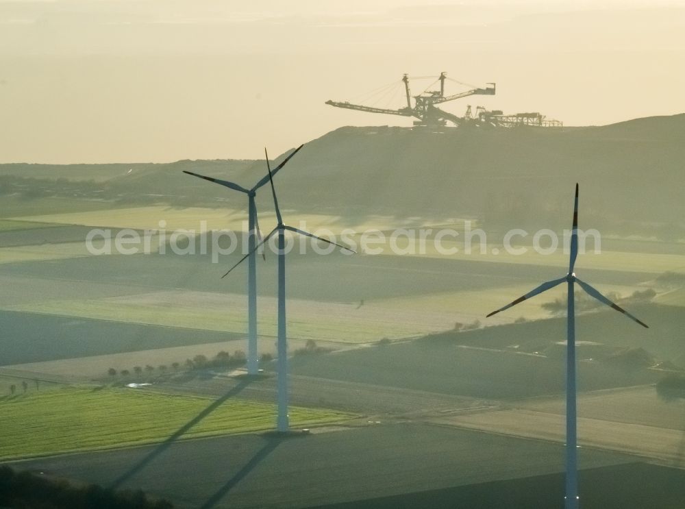 Aerial photograph Titz - Wind turbine windmills on a field in the district Bettenhoven in Titz in the state North Rhine-Westphalia. In the background, the brown coal mine opencast mine Hambach - Etzweiler of RWE Power AG