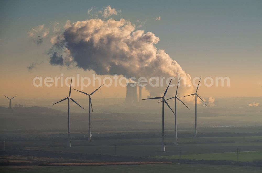 Grevenbroich from the bird's eye view: Wind turbine windmills on a field in the district Frimmersdorf in Grevenbroich in the state North Rhine-Westphalia. In the background, the exhaust gas clouds in the sky above the brown coal power station - Kraftwerk Frimmersdorf of RWE Power