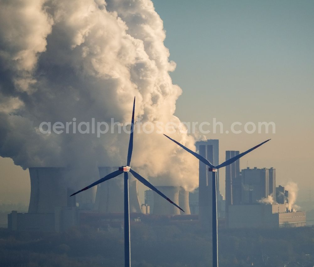 Grevenbroich from above - Wind turbine windmills on a field in the district Frimmersdorf in Grevenbroich in the state North Rhine-Westphalia. In the background, the exhaust gas clouds in the sky above the brown coal power station - Kraftwerk Frimmersdorf of RWE Power