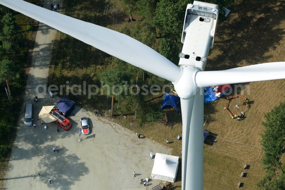 Aerial photograph Sallgast - Wind turbine above the opening party of the forest- windpark Goellnitz-Lieskau-Rehain in Sallgast in the state of Brandenburg. Developed by UKA the largest forest windpark of Germany opens with tents, drinks and stands on the foot of a turbine of Vestas in a forest