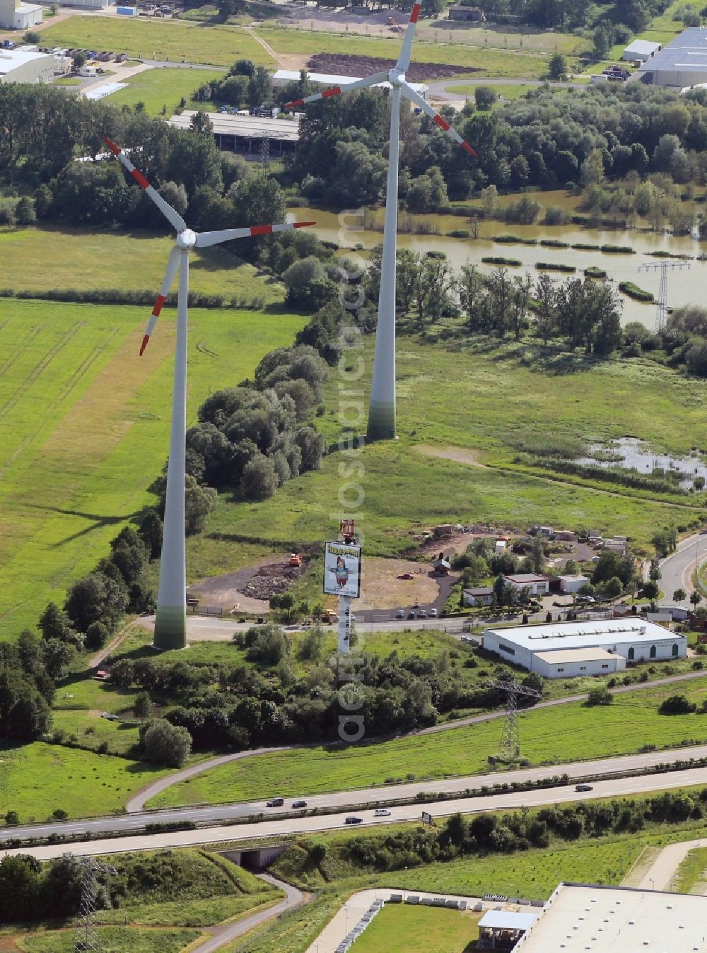 Aerial photograph Waltershausen - The two wind turbines at the Lauchaer Hoehe in Walter Hausen in Thuringia belong to 2000kW wind turbine Hoerselgau. On the factory floor at the foot of the wind turbines, the company KIK Kunststoff GmbH in Walter Hausen their seat