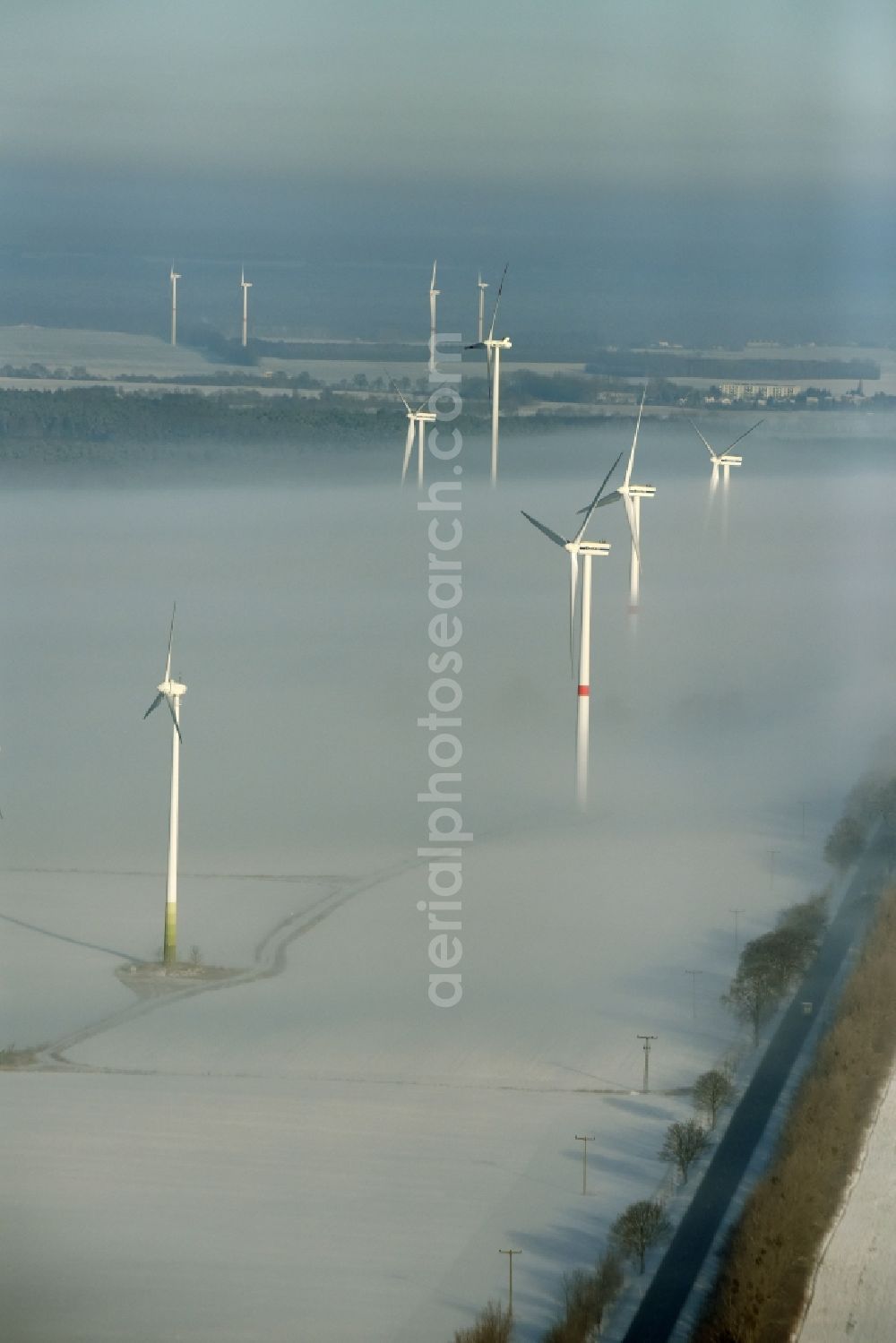 Aerial image Werneuchen - Wind turbine windmills on a winterly snow and fog covered field in Werneuchen in the state of Brandenburg