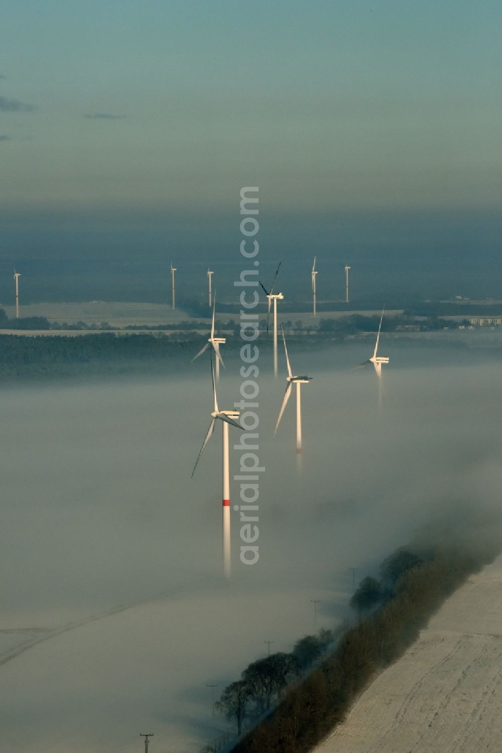 Werneuchen from above - Wind turbine windmills on a winterly snow and fog covered field in Werneuchen in the state of Brandenburg