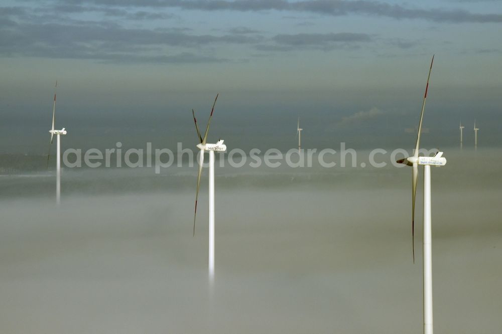 Werneuchen from above - Wind turbine windmills of Saxovent and Stahl Energy on a winterly snow and fog covered field in Werneuchen in the state of Brandenburg