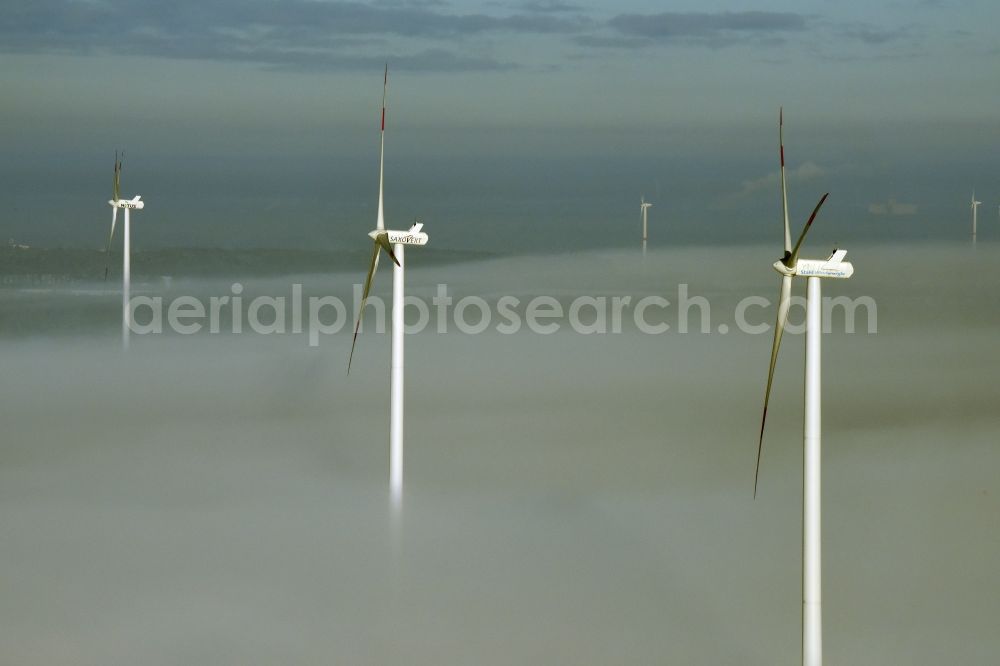 Werneuchen from the bird's eye view: Wind turbine windmills of Saxovent and Stahl Energy on a winterly snow and fog covered field in Werneuchen in the state of Brandenburg