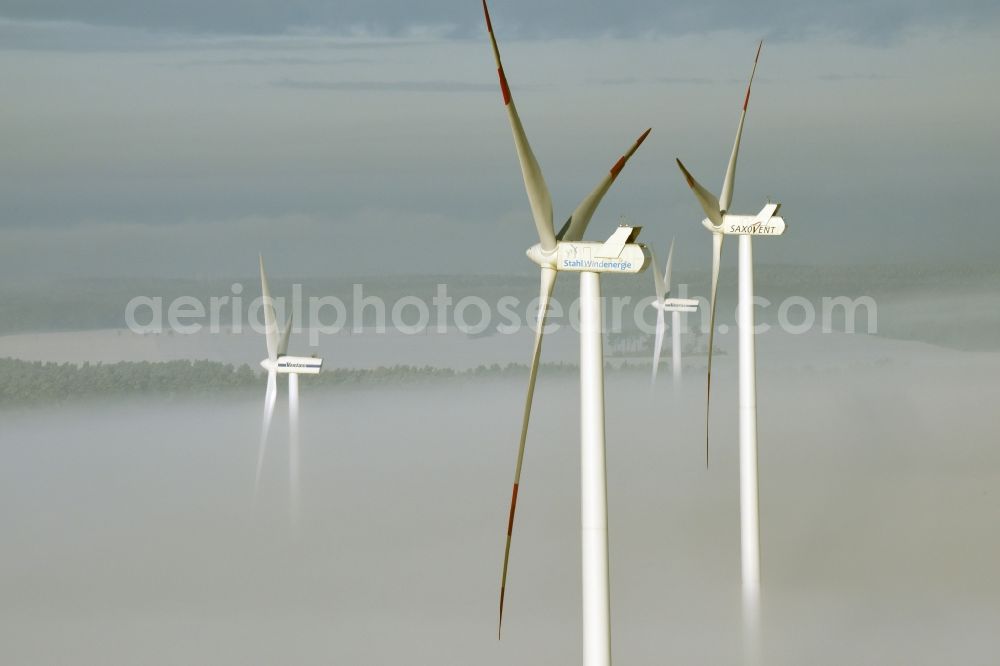 Beiersdorf-Freudenberg from the bird's eye view: Wind turbine windmills of Vestas, Saxovent and Stahl Energy on a winterly snow and fog covered field in Beiersdorf-Freudenberg in the state of Brandenburg