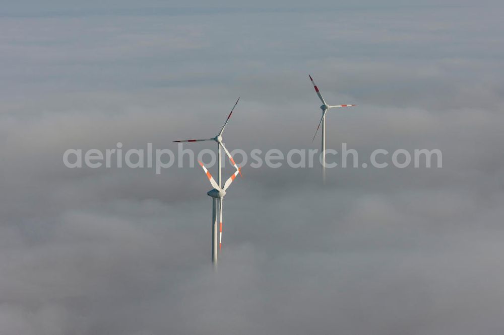 Bretleben from the bird's eye view: Windkrafträder bei Herbstwetter in einer Hochnebel - Wolkendecke bei Bretleben in Thüringen. Wind turbines in the autumn weather in a high fog - cloud cover at Bretleben in Thuringia.