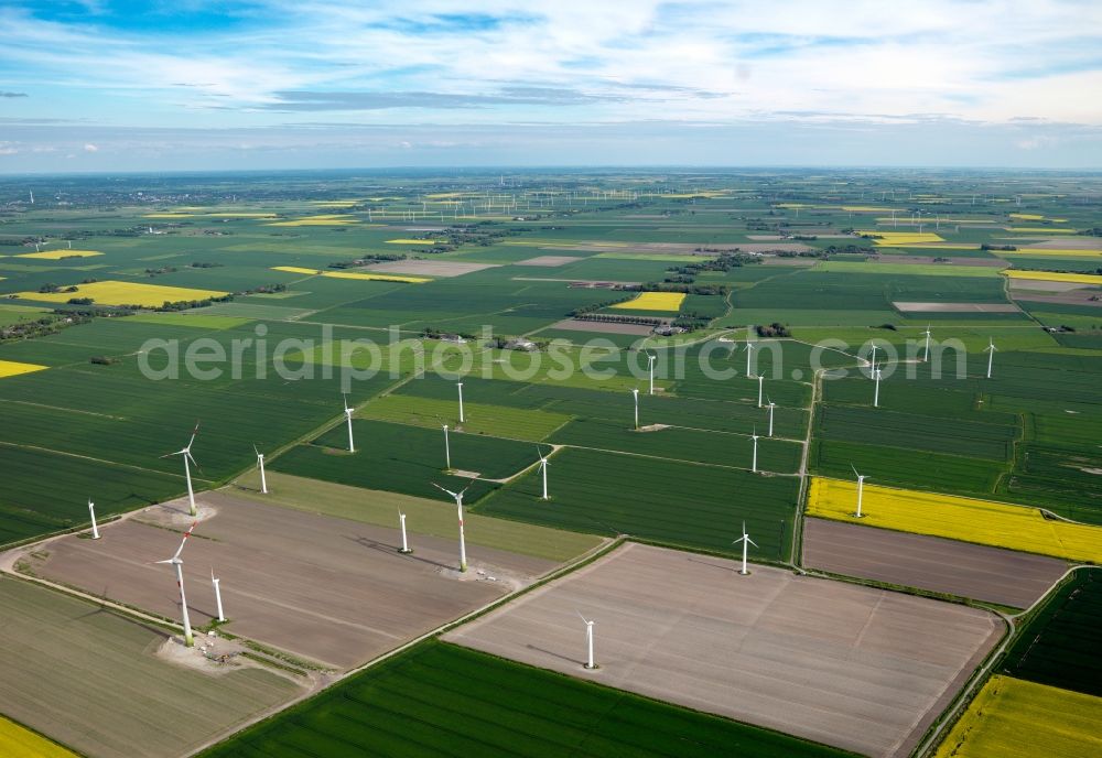 Aerial photograph Heide - Wind power wheels and turbines in the county district of Dithmarschen near Heide in the state of Schleswig-Holstein. The turbines are placed between fields. Overview of the agricultural structures as well as the wheels used to create energy