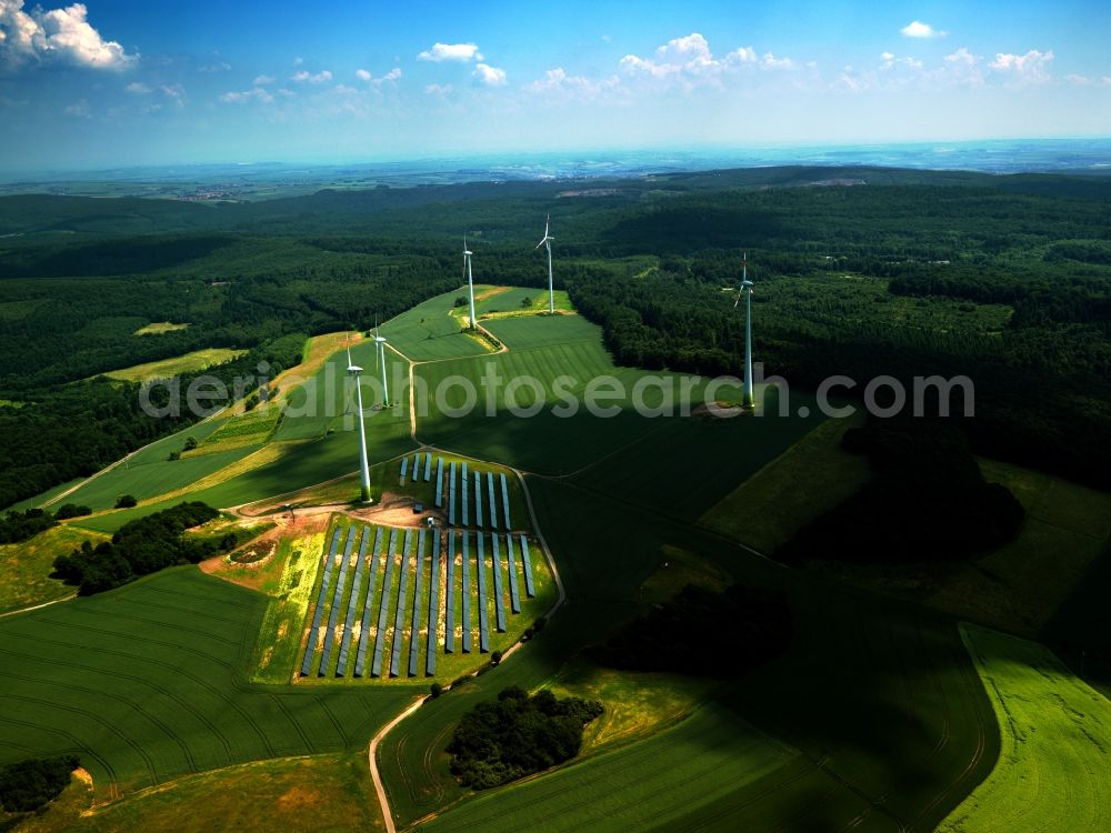 Aerial image Gerbach - Wind power wheels and turbines in the county district of Gerbach in the Donnersberg region in the state of Rhineland-Palatinate. The turbines are placed between fields and surrounded by the solar cells of the solar compound. Overview of the agricultural structures as well as the wheels used to create energy