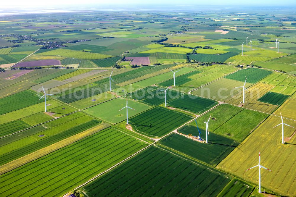 Aerial photograph Galmsbüll - Wind turbines of a wind power plant Gotteskoogdeich on agricultural land and fields on the edge of the settlement area of the village in Galmsbuell North Friesland in the state Schleswig-Holstein, Germany