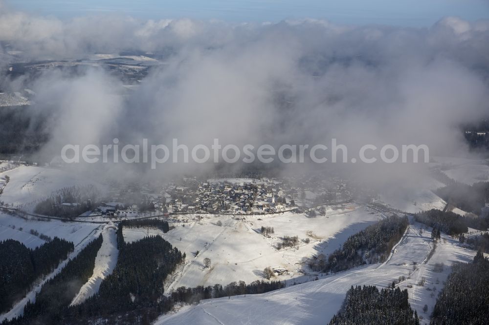 Aerial image Schmallenberg - View of the partially snow covered, foggy and cloudy winter landscape of Schmallenberg in the state of North Rhine-Westphalia