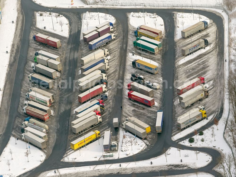 Hamm from the bird's eye view: Winter - landscape of snow-covered truck parking at the rest area Hamm, a welcome for driving periods - used breaks in freight resting place in Hamm in North Rhine-Westphalia