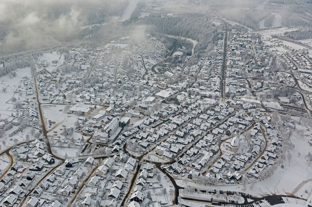 Winterberg from above - Winter city view from the snow-covered city center to the tourist center Oversum in Winterberg in North Rhine-Westphalia NRW. The Oversum Vital Resort Winterberg is a hotel - complex with gym and spa