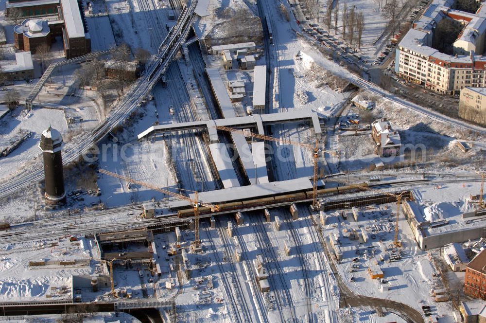 Berlin from above - Wintereinbruch beim Um- und Neubau des Berliner S-Bahnhofs Ostkreuz. Trotz Schnee laufen die Arbeiten weiter. Der Bahnhof wurde bereits im Jahr 1882 eröffnet und ist somit stark sanierungsbedürftig. Teile der Neubauten führt die EUROVIA Beton GmbH aus. Weiterhin beteiligt ist das Unternehmen VEPRO Verkehrsbauprojekt GmbH. Kontakt EUROVIA: EUROVIA BEton GmbH, Niederlassung Ingenieurbau und Zweigniederlassung Cottbus, Gewerbeparkstraße 17, 03099 Kolkwitz, Tel. +49(0)355 35552 3, Fax +49(0)355 35552 52, EMail: ingenieurbau@eurovia.de; Kontakt VEPRO: Verkehrsbau Projekt GmbH, Storkower Str. 132, 10407 Berlin, Tel. +49(0)30 42194 0, Fax +49(0)30 42194 221