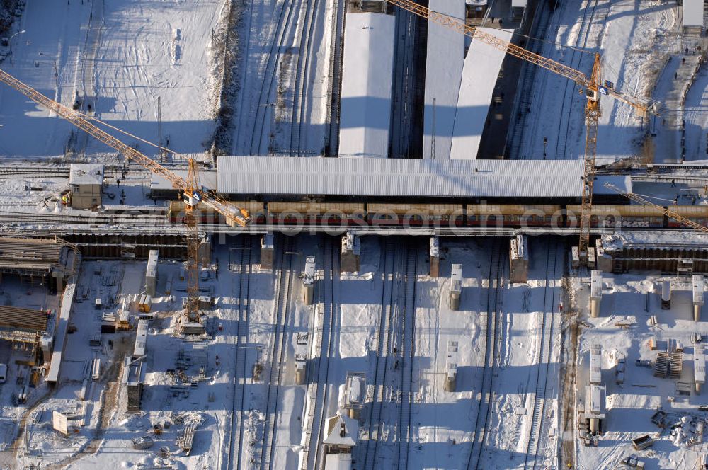 Aerial photograph Berlin - Wintereinbruch beim Um- und Neubau des Berliner S-Bahnhofs Ostkreuz. Trotz Schnee laufen die Arbeiten weiter. Der Bahnhof wurde bereits im Jahr 1882 eröffnet und ist somit stark sanierungsbedürftig. Teile der Neubauten führt die EUROVIA Beton GmbH aus. Weiterhin beteiligt ist das Unternehmen VEPRO Verkehrsbauprojekt GmbH. Kontakt EUROVIA: EUROVIA BEton GmbH, Niederlassung Ingenieurbau und Zweigniederlassung Cottbus, Gewerbeparkstraße 17, 03099 Kolkwitz, Tel. +49(0)355 35552 3, Fax +49(0)355 35552 52, EMail: ingenieurbau@eurovia.de; Kontakt VEPRO: Verkehrsbau Projekt GmbH, Storkower Str. 132, 10407 Berlin, Tel. +49(0)30 42194 0, Fax +49(0)30 42194 221