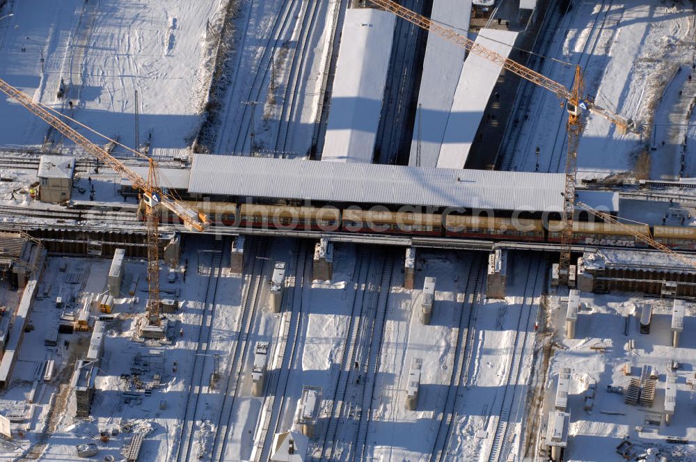 Berlin from above - Wintereinbruch beim Um- und Neubau des Berliner S-Bahnhofs Ostkreuz. Trotz Schnee laufen die Arbeiten weiter. Der Bahnhof wurde bereits im Jahr 1882 eröffnet und ist somit stark sanierungsbedürftig. Teile der Neubauten führt die EUROVIA Beton GmbH aus. Weiterhin beteiligt ist das Unternehmen VEPRO Verkehrsbauprojekt GmbH. Kontakt EUROVIA: EUROVIA BEton GmbH, Niederlassung Ingenieurbau und Zweigniederlassung Cottbus, Gewerbeparkstraße 17, 03099 Kolkwitz, Tel. +49(0)355 35552 3, Fax +49(0)355 35552 52, EMail: ingenieurbau@eurovia.de; Kontakt VEPRO: Verkehrsbau Projekt GmbH, Storkower Str. 132, 10407 Berlin, Tel. +49(0)30 42194 0, Fax +49(0)30 42194 221