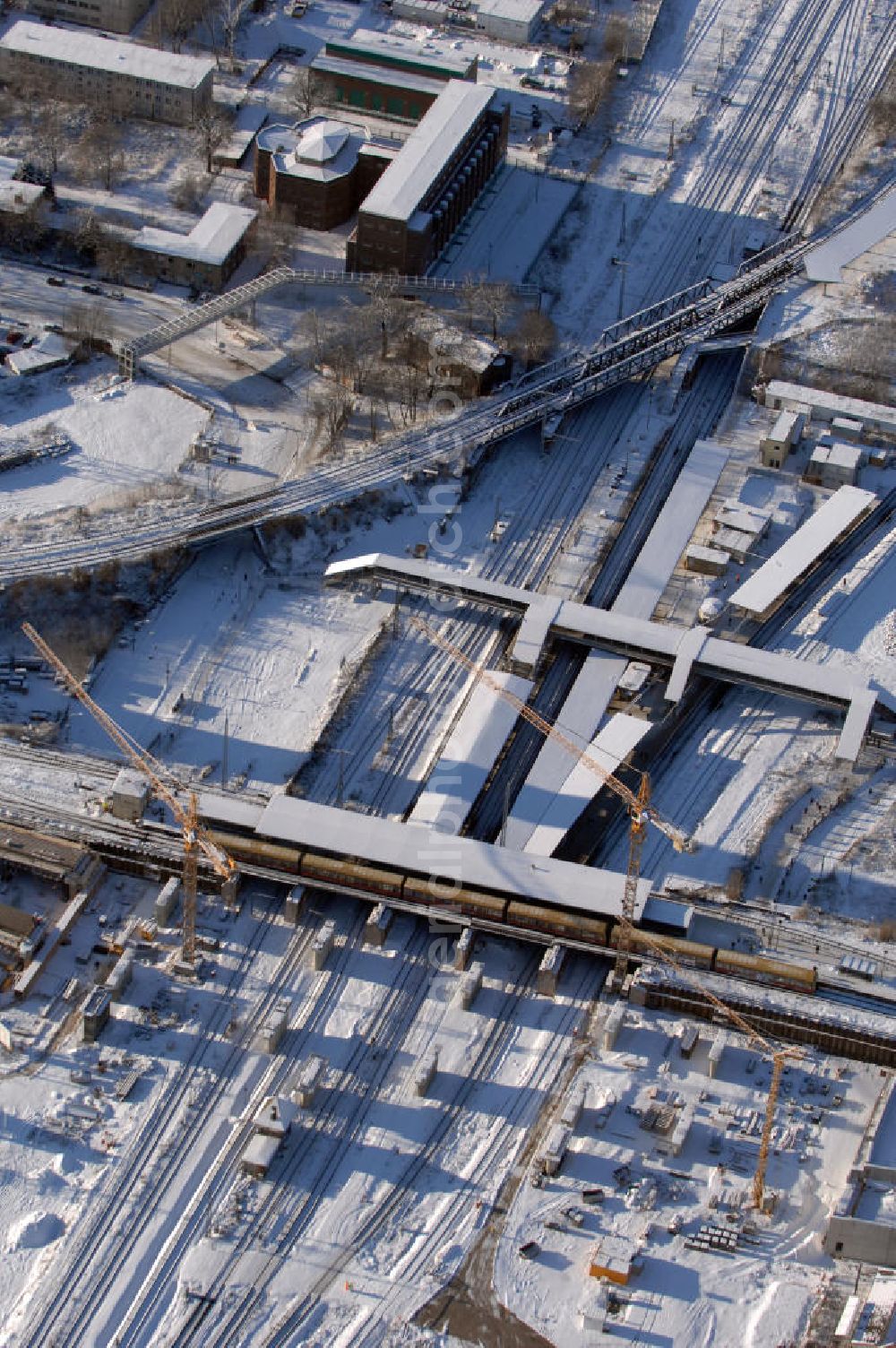 Berlin from the bird's eye view: Wintereinbruch beim Um- und Neubau des Berliner S-Bahnhofs Ostkreuz. Trotz Schnee laufen die Arbeiten weiter. Der Bahnhof wurde bereits im Jahr 1882 eröffnet und ist somit stark sanierungsbedürftig. Teile der Neubauten führt die EUROVIA Beton GmbH aus. Weiterhin beteiligt ist das Unternehmen VEPRO Verkehrsbauprojekt GmbH. Kontakt EUROVIA: EUROVIA BEton GmbH, Niederlassung Ingenieurbau und Zweigniederlassung Cottbus, Gewerbeparkstraße 17, 03099 Kolkwitz, Tel. +49(0)355 35552 3, Fax +49(0)355 35552 52, EMail: ingenieurbau@eurovia.de; Kontakt VEPRO: Verkehrsbau Projekt GmbH, Storkower Str. 132, 10407 Berlin, Tel. +49(0)30 42194 0, Fax +49(0)30 42194 221