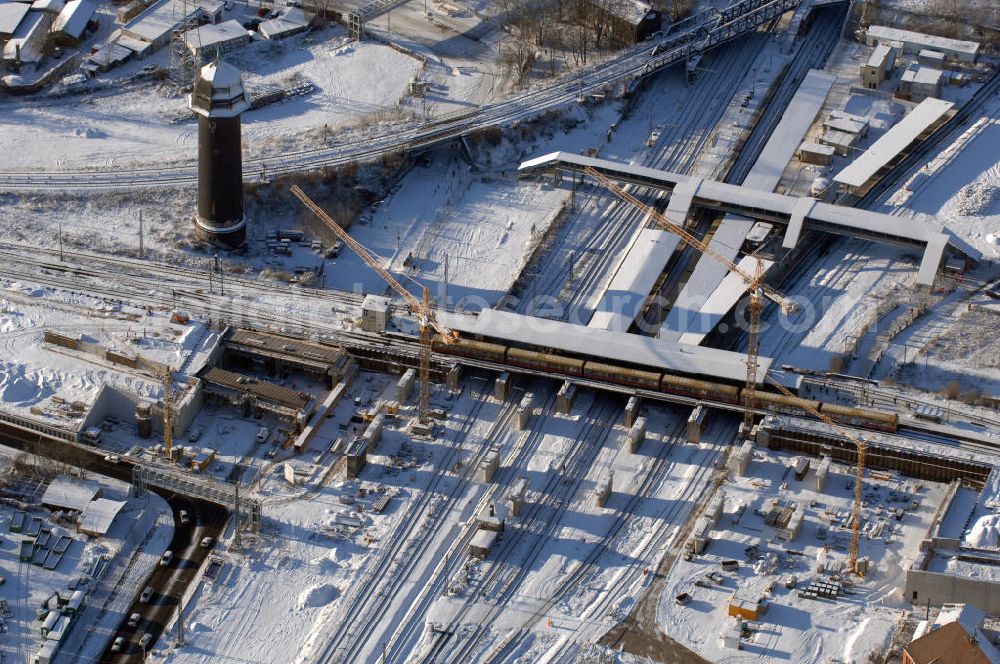 Berlin from above - Wintereinbruch beim Um- und Neubau des Berliner S-Bahnhofs Ostkreuz. Trotz Schnee laufen die Arbeiten weiter. Der Bahnhof wurde bereits im Jahr 1882 eröffnet und ist somit stark sanierungsbedürftig. Teile der Neubauten führt die EUROVIA Beton GmbH aus. Weiterhin beteiligt ist das Unternehmen VEPRO Verkehrsbauprojekt GmbH. Kontakt EUROVIA: EUROVIA BEton GmbH, Niederlassung Ingenieurbau und Zweigniederlassung Cottbus, Gewerbeparkstraße 17, 03099 Kolkwitz, Tel. +49(0)355 35552 3, Fax +49(0)355 35552 52, EMail: ingenieurbau@eurovia.de; Kontakt VEPRO: Verkehrsbau Projekt GmbH, Storkower Str. 132, 10407 Berlin, Tel. +49(0)30 42194 0, Fax +49(0)30 42194 221