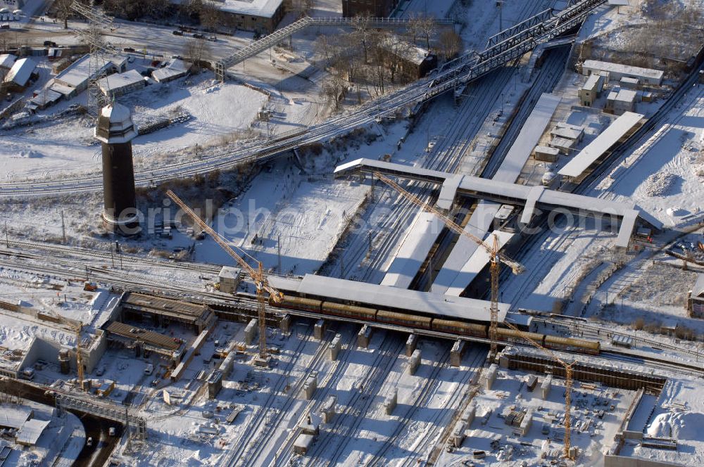 Berlin from the bird's eye view: Wintereinbruch beim Um- und Neubau des Berliner S-Bahnhofs Ostkreuz. Trotz Schnee laufen die Arbeiten weiter. Der Bahnhof wurde bereits im Jahr 1882 eröffnet und ist somit stark sanierungsbedürftig. Teile der Neubauten führt die EUROVIA Beton GmbH aus. Weiterhin beteiligt ist das Unternehmen VEPRO Verkehrsbauprojekt GmbH. Kontakt EUROVIA: EUROVIA BEton GmbH, Niederlassung Ingenieurbau und Zweigniederlassung Cottbus, Gewerbeparkstraße 17, 03099 Kolkwitz, Tel. +49(0)355 35552 3, Fax +49(0)355 35552 52, EMail: ingenieurbau@eurovia.de; Kontakt VEPRO: Verkehrsbau Projekt GmbH, Storkower Str. 132, 10407 Berlin, Tel. +49(0)30 42194 0, Fax +49(0)30 42194 221