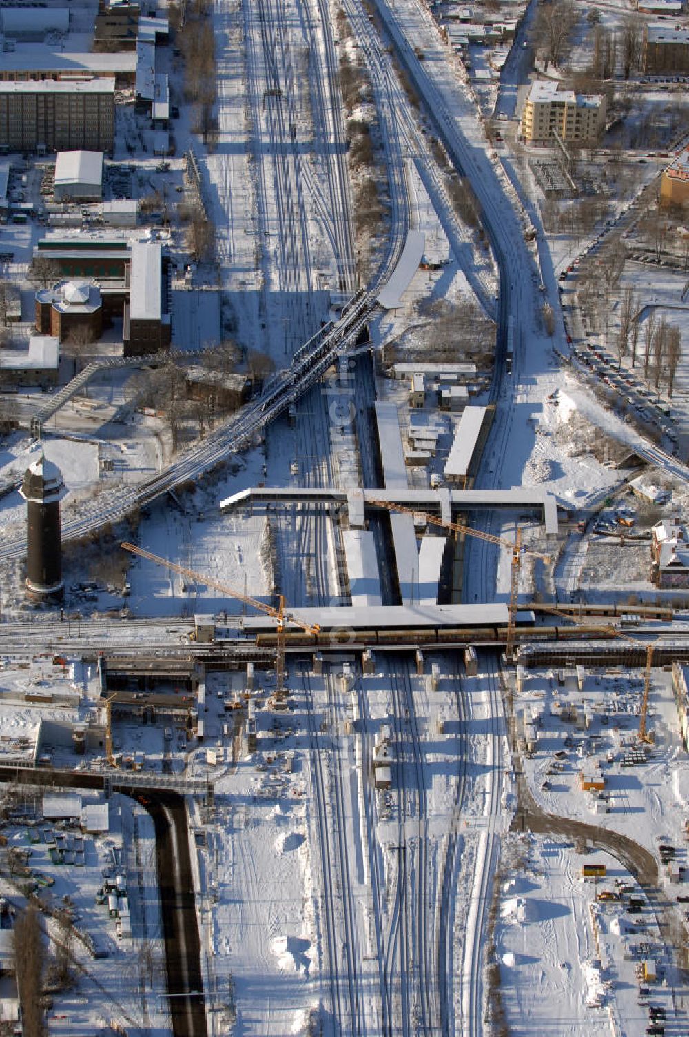 Aerial photograph Berlin - Wintereinbruch beim Um- und Neubau des Berliner S-Bahnhofs Ostkreuz. Trotz Schnee laufen die Arbeiten weiter. Der Bahnhof wurde bereits im Jahr 1882 eröffnet und ist somit stark sanierungsbedürftig. Teile der Neubauten führt die EUROVIA Beton GmbH aus. Weiterhin beteiligt ist das Unternehmen VEPRO Verkehrsbauprojekt GmbH. Kontakt EUROVIA: EUROVIA BEton GmbH, Niederlassung Ingenieurbau und Zweigniederlassung Cottbus, Gewerbeparkstraße 17, 03099 Kolkwitz, Tel. +49(0)355 35552 3, Fax +49(0)355 35552 52, EMail: ingenieurbau@eurovia.de; Kontakt VEPRO: Verkehrsbau Projekt GmbH, Storkower Str. 132, 10407 Berlin, Tel. +49(0)30 42194 0, Fax +49(0)30 42194 221