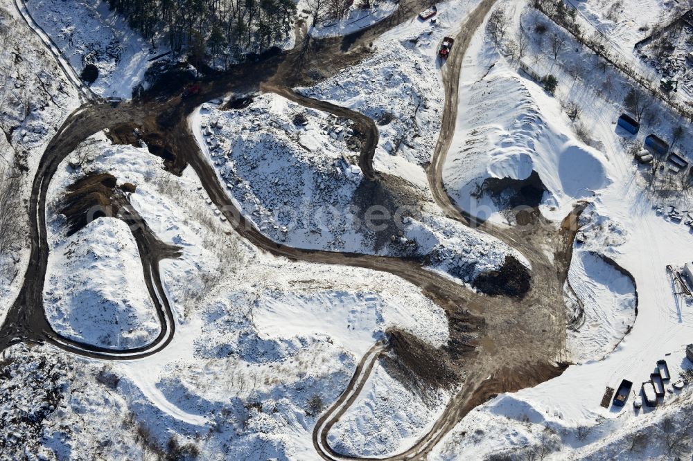 Berlin from the bird's eye view: Wintry road covered with snow the recycling of building materials and soil treatment company in the cemetery road Berlin - Mahlsdorf