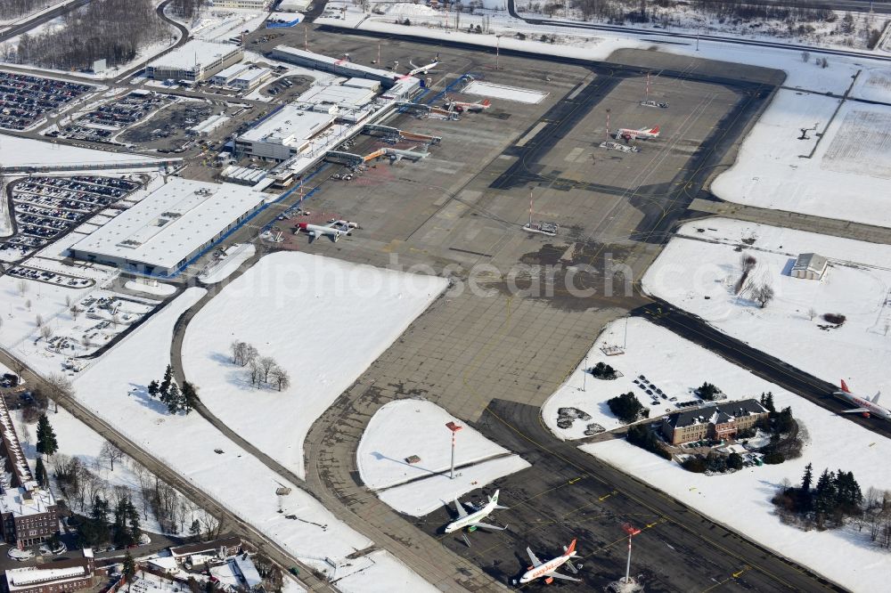 Aerial image Schönefeld - Winter covered with snow runways, taxiways, terminal building and old DDR terminal from INTERFLUG times at Berlin - Schonefeld