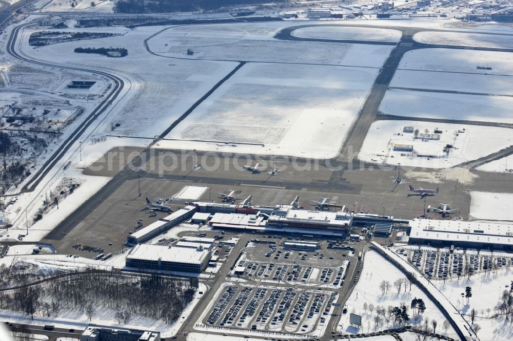 Aerial photograph Schönefeld - Winter covered with snow runways, taxiways, terminal building and old DDR terminal from INTERFLUG times at Berlin - Schonefeld