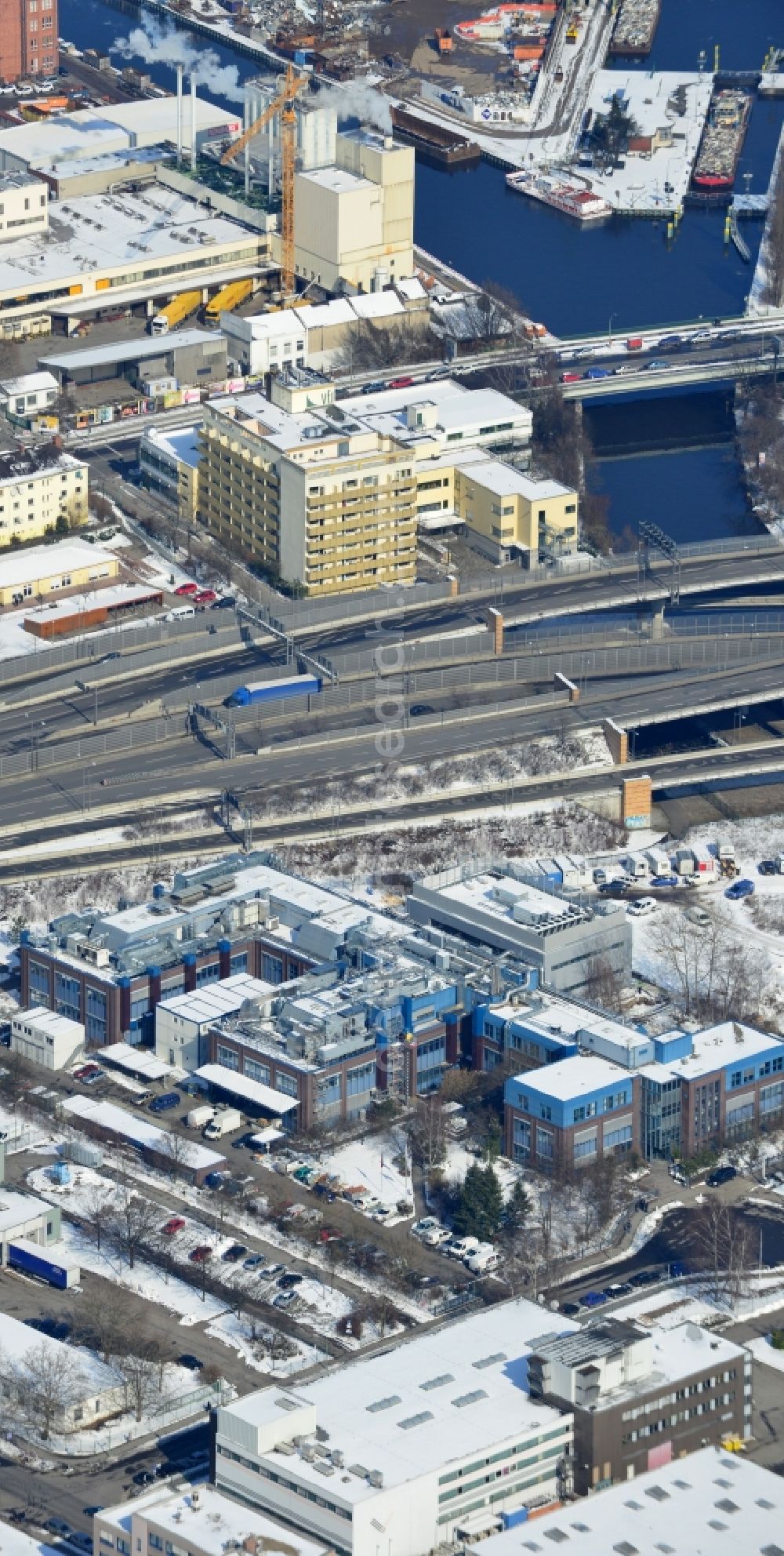 Aerial photograph Berlin Neukölln - Winter with snow covered grounds of the BIOTRONIK SE & Co. KG at the Woermannkehre in Berlin Neukölln