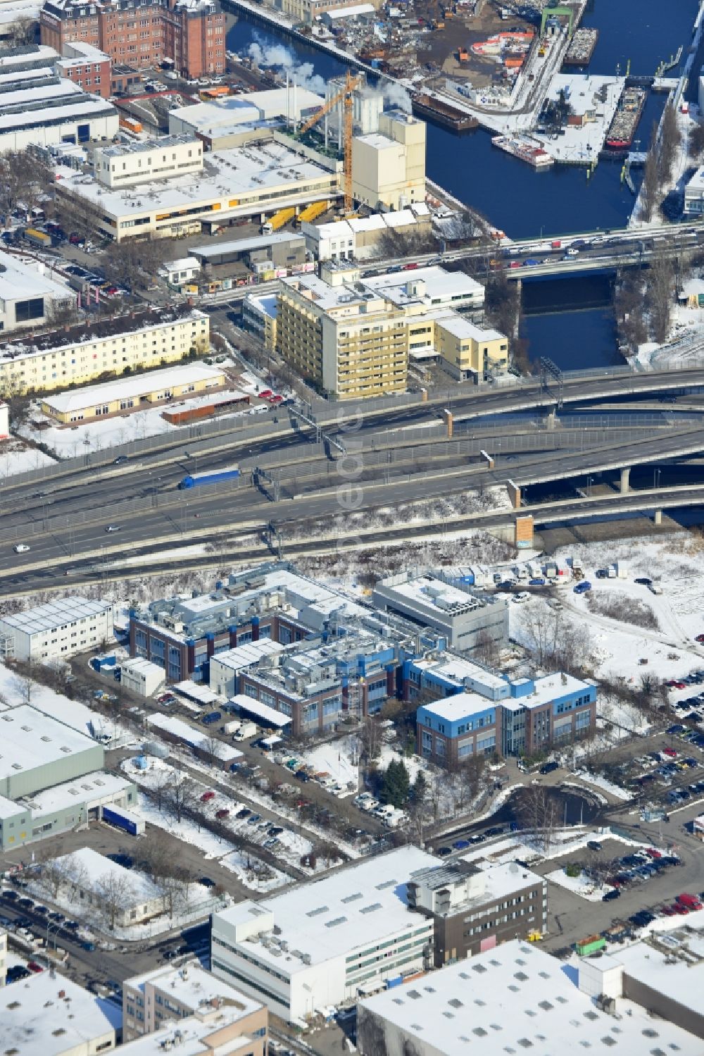 Berlin Neukölln from the bird's eye view: Winter with snow covered grounds of the BIOTRONIK SE & Co. KG at the Woermannkehre in Berlin Neukölln