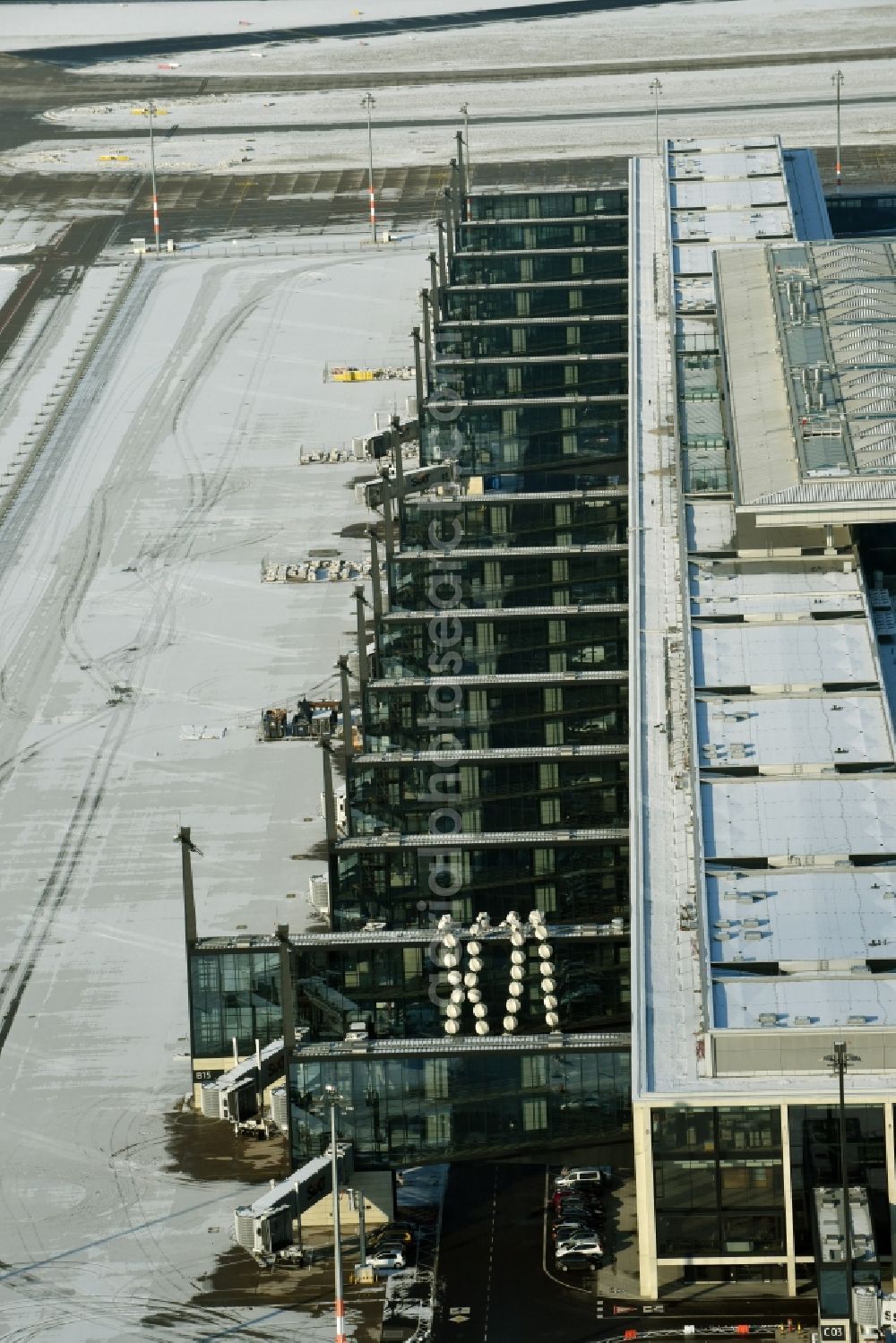 Schönefeld from above - Wintry snowy dispatch building and terminals on the premises of the airport BER in Schoenefeld in the state Brandenburg