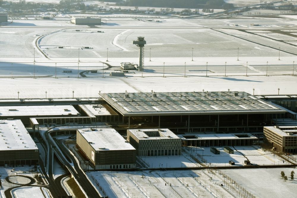 Schönefeld from the bird's eye view: Wintry snowy dispatch building and terminals on the premises of the airport BER in Schoenefeld in the state Brandenburg