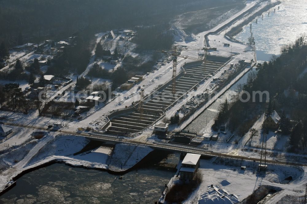 Zerben from the bird's eye view: Wintry snowy construction site at the Zerben sluice, bridge and the riverside of the Elbe-Havel-Canel in the state Saxony-Anhalt