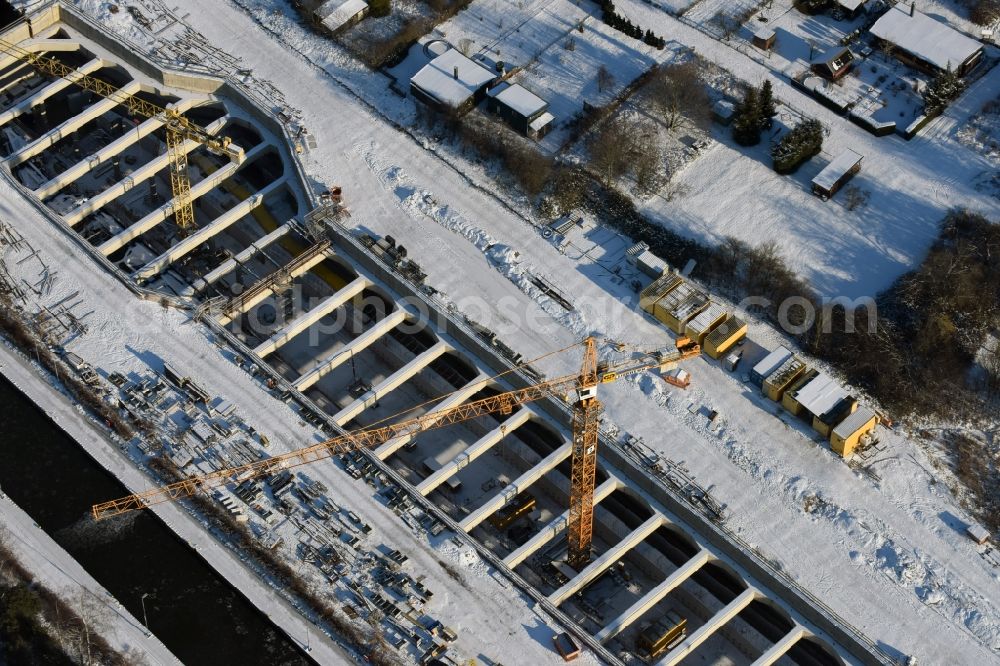 Zerben from the bird's eye view: Wintry snowy construction site at the Zerben sluice, bridge and the riverside of the Elbe-Havel-Canel in the state Saxony-Anhalt