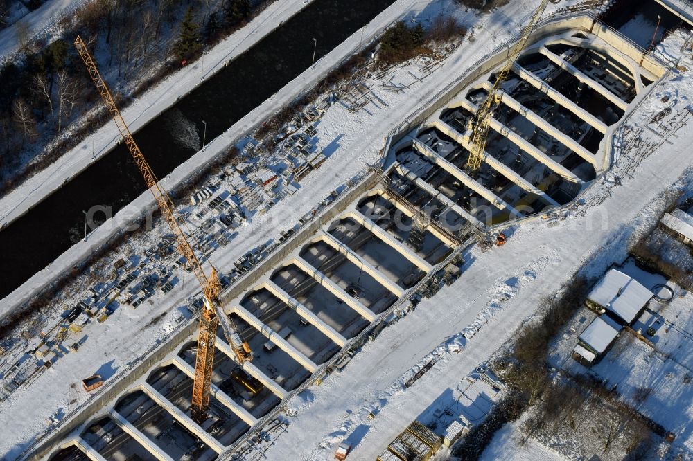 Zerben from the bird's eye view: Wintry snowy construction site at the Zerben sluice, bridge and the riverside of the Elbe-Havel-Canel in the state Saxony-Anhalt